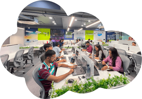 Modern office workspace with people working on laptops and computers